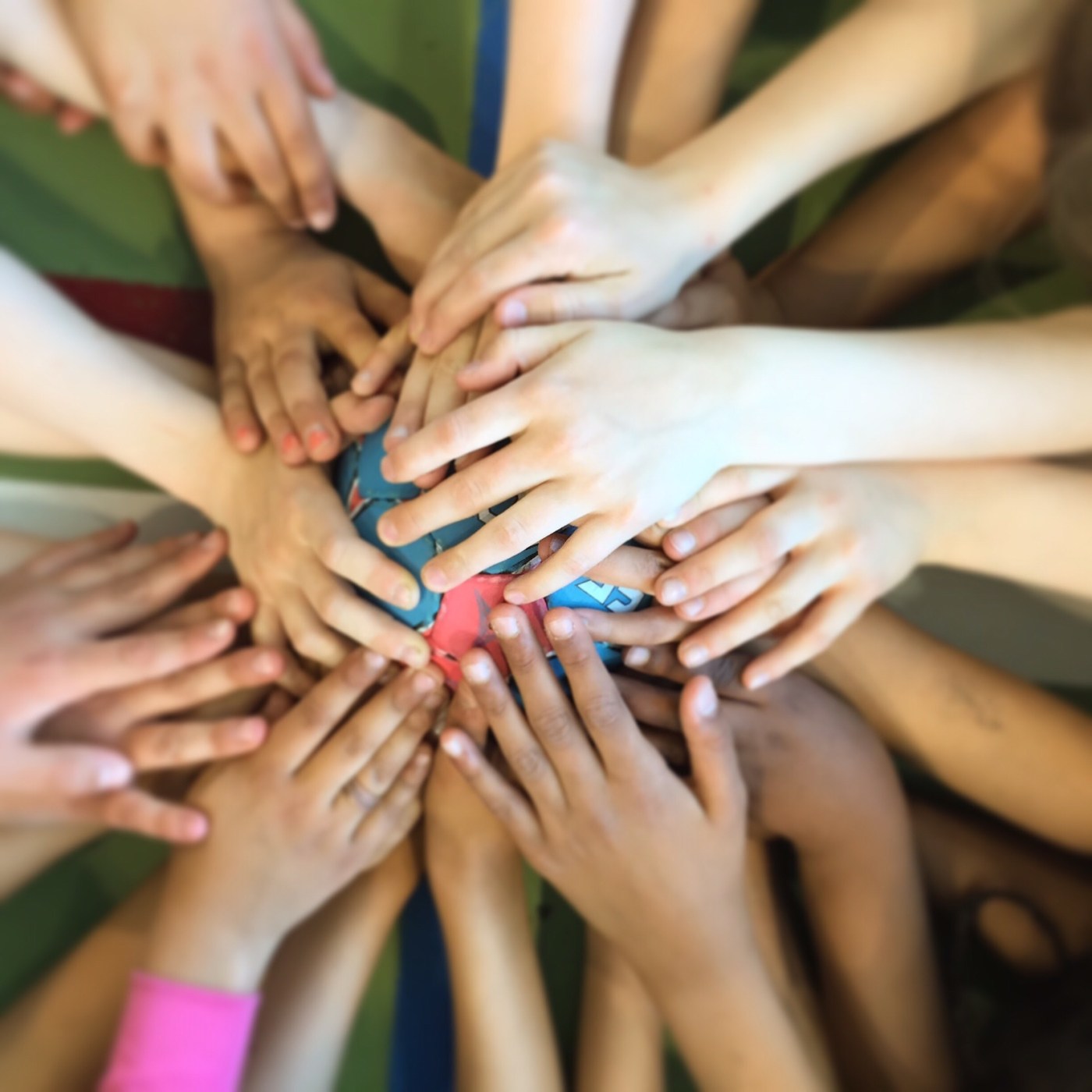 Mange hender som holder en håndball